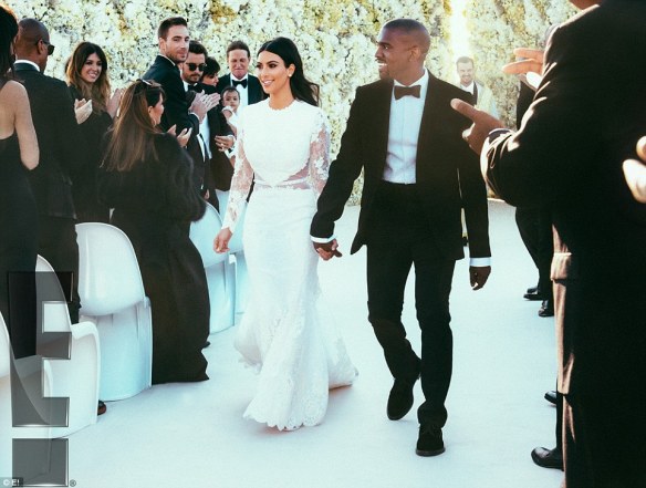 Kim and Kanye look beaming with happiness as they walk hand-in-hand down the aisle after getting married at their lavish wedding